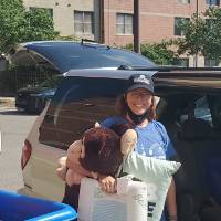 Sara Maas helps a student unload their belongings